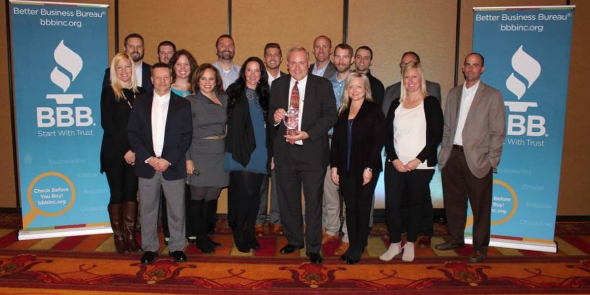 Group of NMC Cat employees at Better Business Bureau event with award