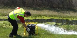 man using a trash pump rental machine